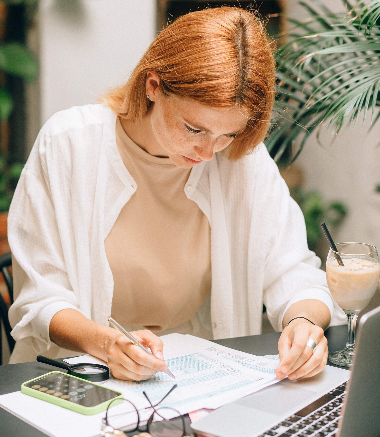 Payroll Services Female Accountant with red hair working on taxes